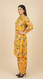 Woman wearing a yellow floral dress against a beige background