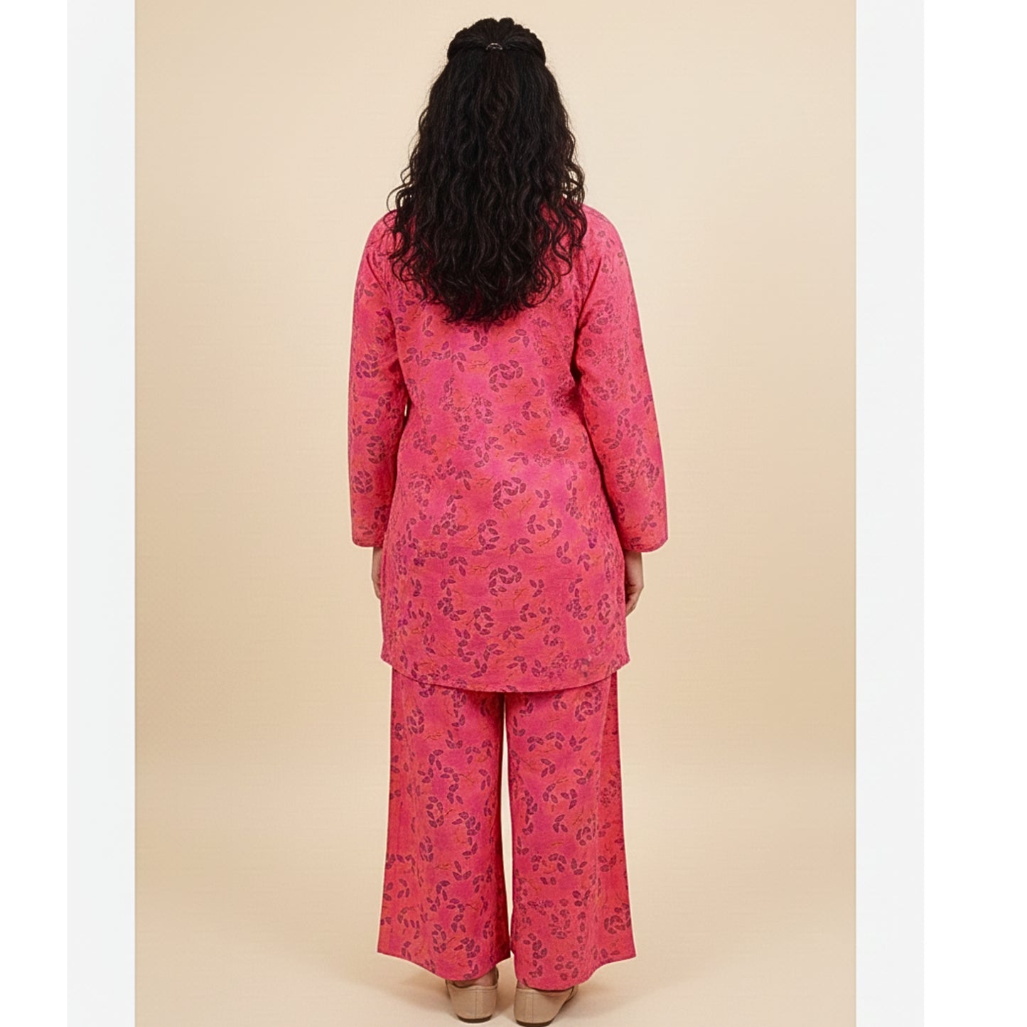 Woman wearing a pink floral outfit against a beige background