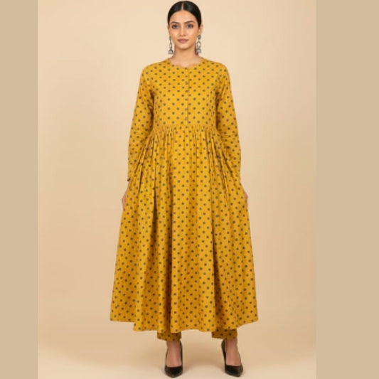 Woman wearing a yellow dress with black patterns on a beige background