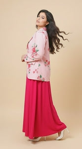 Woman wearing a pink floral top and red skirt on a beige background